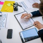 Team reviewing financial charts and digital data on tablets in an office setting. — Forex Risk Management Tools Designed for